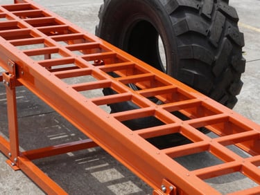 Sharp industrial product photography of a heavy-duty RV leveling ramp under a massive tire, showing the interlocking structural grid of the high-strength orange polymer, 50mm.