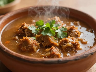 Traditional Mexican aporreadillo stew in a clay dish, steaming, fresh cilantro garnish, warm natural light, shallow depth of field, 35mm