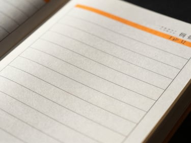 Macro close-up of a flat-lay planner page, showing clean monospaced grids, sharp black ink lines, high-contrast safety orange accents, dramatic side-lighting.