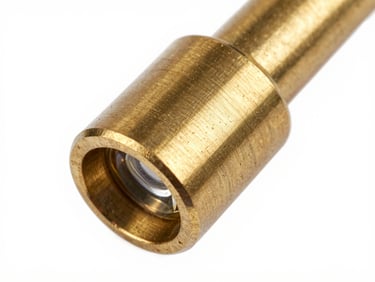 Close-up macro shot of a brushed brass pendant fixture joint, studio strobe light raking across the machined surface to reveal the grain of the metal, stark white background, clinical framing, no context objects