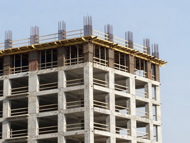 Active construction site showing modern high-rise building structural concrete core, steel reinforcement, bright daylight