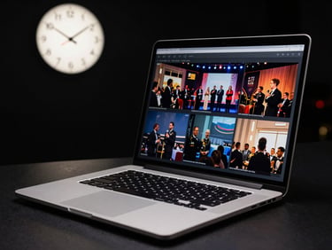 A sleek, modern laptop displaying event photography, with a clock showing early morning hours in the background, high-contrast, editorial style.