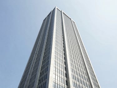 Wide-angle architectural photography of Menara Binjai corporate tower exterior, bright natural daylight, clean high-contrast corporate tones