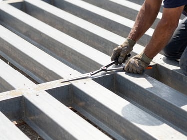 Close-up of a construction worker performing a quality check on a steel beam with precision tools, bright natural daylight, high-contrast structural details.