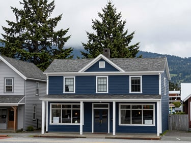 A historic coastal storefront in Port Townsend, soft overcast daylight, Olympic mountains faintly visible in the far background.