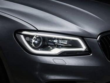 Moody close-up of a brushed steel automotive detail, sharp headlights reflecting high-contrast studio strobes, 35mm lens