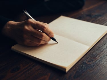 Una mano sosteniendo un documento sellado con un bolígrafo, sobre un fondo oscuro de mesa de madera, iluminación de bajo contraste, tonos azules y dorados.