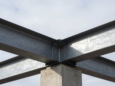 Close-up of raw concrete and structural steel joints under crisp overcast Helsinki daylight.
