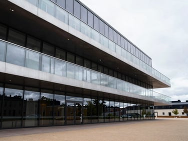 Crisp overcast daylight reflecting off a modern steel and glass architectural structure in Helsinki, clean minimalist lines, high-contrast