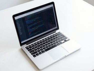 Overhead shot of a clean, structured workspace with a laptop displaying clean Python code, cool blue tones, daylight