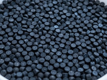 Close-up of extruded cylindrical activated carbon pellets, uniform shape, clean warehouse daylight, technical blue tint