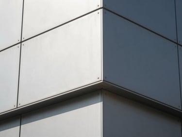 Close-up of ACP aluminium composite panel joints on a commercial building facade in sharp midday light, geometric grid lines casting thin shadows, silver and charcoal panel surfaces reading with precise material flatness