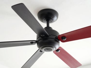 Close-up of a modern matte black ceiling fan being wired into a clean white ceiling, bright natural daylight, high contrast red and black tones, 35mm