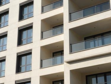 Architectural photograph of a modern apartment building exterior with clean architectural lines and pristine paint finishes, natural daylight, 35mm lens.