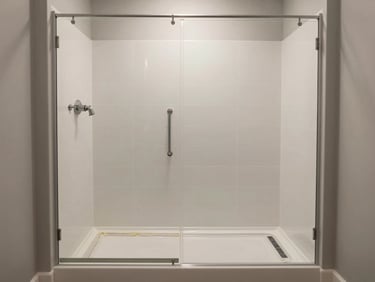 Medium shot of a fully restored walk-in shower — clean grout lines, fresh caulk at the base, consistent overhead light showing the complete after state in a real Florida bathroom