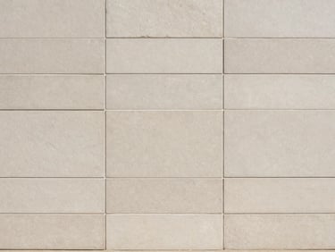 Matte ceramic wall tiles in soft neutral tones, clean daylight showroom display, 35mm