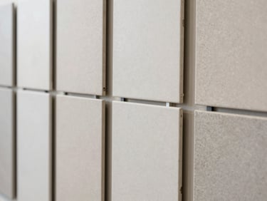 Neatly stacked ceramic wall tiles in a bright showroom display, matte finish, soft natural light