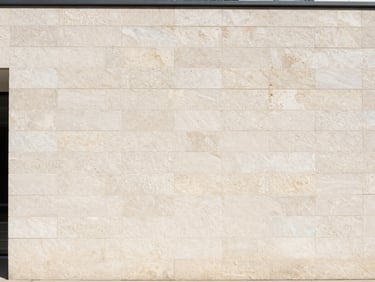 Textured exterior elevation cladding tiles on a modern building facade, bright daylight, 35mm