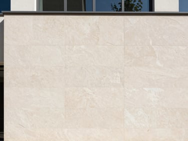 Architectural shot of modern exterior building facade with textured stone-look elevation cladding, daylight