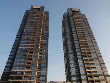 Symmetrical low-angle shot of modern glass residential towers under golden hour sky, Sector 63 Gurgaon