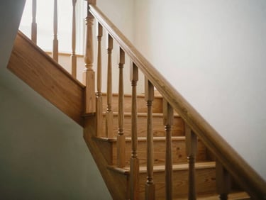 A newly installed oak staircase, clean lines, warm natural window light, shallow depth of field, warm editorial photography.