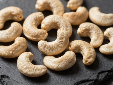 Extreme close-up of raw cashews on a dark slate background, sharp dramatic side lighting