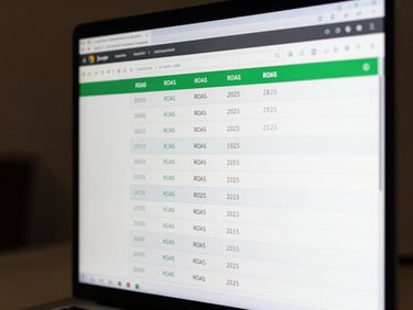 Close-up of a computer monitor displaying a Google Ads campaign dashboard with clear ROAS and conversion metrics, sharp studio lighting, readable KPI numbers in green and white against a dark interface, tight framing on the screen