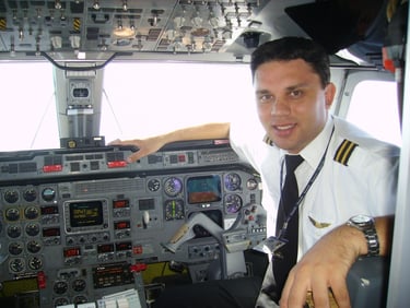 a man in uniform is sitting in a plane emb120 flightdeck