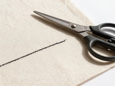 Macro shot of a chalk line drafted on structured cream linen fabric, a pair of heavy tailor shears resting nearby, bright natural daylight, 35mm