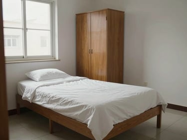 Medium environmental shot of a single-occupancy PG room, neatly made bed with white linen, wooden wardrobe against the wall, natural daylight from a side window, clean tiled floor, no clutter, honest documentary framing