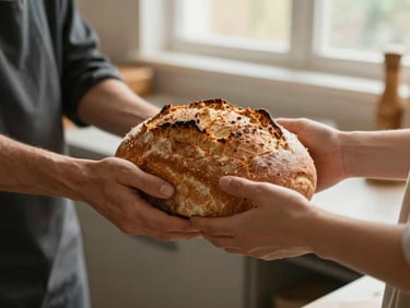 A close-up of hands passing a warm, freshly baked loaf of bread in a bright, clean community kitchen, soft window light, rich earthy tones.