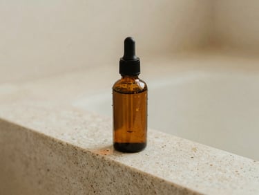 Amber glass skincare bottle resting on a travertine stone ledge, soft water droplets, diffused natural light.