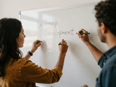 Active hands-on leadership development session, group of diverse change-makers writing on a whiteboard, natural daylight.