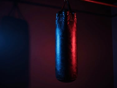 Dramatic low angle of an MMA heavy bag in a dark studio, deep shadows, electric blue rim light, 35mm