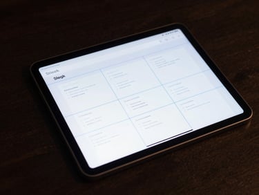 Sleek web design interface wireframe with clean layout grids and neon blue guides on a dark glass tablet, moody lighting.