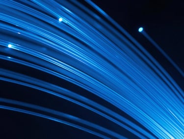 Crisp commercial photography, glowing blue fiber optic strands macro shot, high contrast studio lighting, sharp focus.