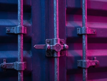 Macro shot of a heavy-duty steel cargo container lock with a secure numbered seal, dramatic high-contrast industrial lighting, 35mm.
