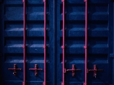 High-contrast close-up of shipping container locks and seals at a busy Jakarta port, dramatic industrial lighting with deep blue shadows and sharp magenta accents, 35mm