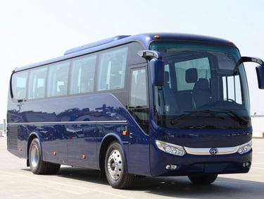 Front-three-quarter view of a massive modern dark blue double-axle tourist coach bus, bright morning daylight, crisp commercial vehicle photography