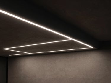 Minimalist modern office interior at night, sharp linear LED light fixtures recessed into a dark concrete ceiling casting precise cool-white beams downward, medium format.