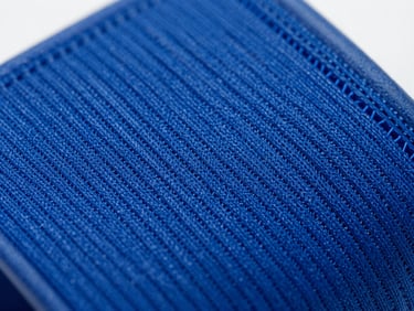 Macro close-up of an electric blue smart armband fabric, showing the intricate technical weave and bio-compatible elastic fibers, crisp studio lighting