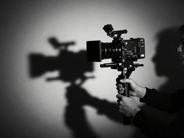Hands mounting a cinema camera on a stabilizer, dramatic shadows, high-contrast black and white.