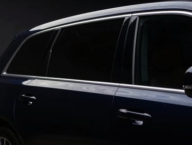 Low-angle heroic car portrait, rear windows with a very dark limo tint, sharp LED reflections, deep glossy paint, dark low-key automotive photography, 50mm