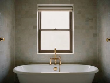 Straight-on view of a luxury bathroom wet room with a freestanding tub, zellige tiles, and brushed brass fixtures