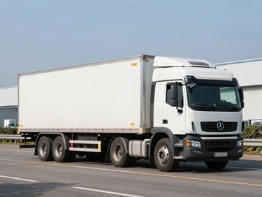 A heavy-duty commercial cargo truck with an attached flatbed trailer, positioned on an open highway under clear skies.