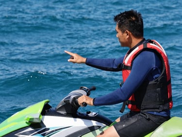 Close-up of a certified instructor in a wetsuit, wearing a life jacket, giving clear instructions to a student on a jet ski, deep blue water background, high-contrast sunlight