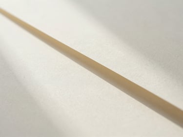 Abstract light refraction and soft shadows cast on a clean, minimalist cream textured paper surface, clinical aesthetic