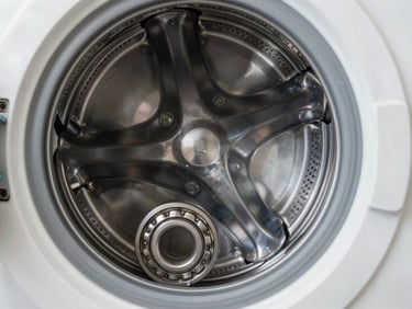 A neatly repaired washing machine drum assembly with a brand new bearing kit installed, clean metal surfaces, technical precision