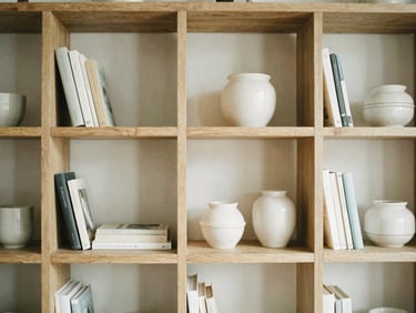 Organized oak shelving unit with books and ceramic pots, soft diffused daylight, clean lines