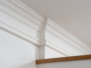 Detail architectural photography of crisp crown molding and staircase trim, tight miter joints, bright natural daylight, 35mm lens